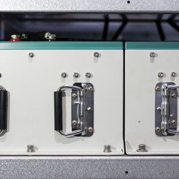 Image showing a of supercapacitor modules. A close up of the front of two supercapacitor modules. The modules are rectangular with each having two carrying handles and anode and cathode connections.