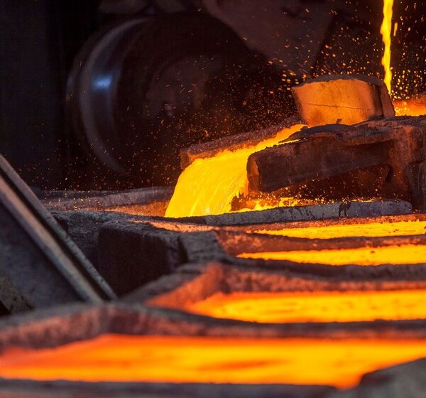 Image showing molten iron being cast into ingots. A carousel of metal ingots are being filled in turn by a steam of red-glowing iron.