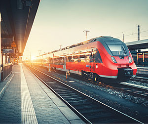 Image showing a modern train pulling into a station at sunrise