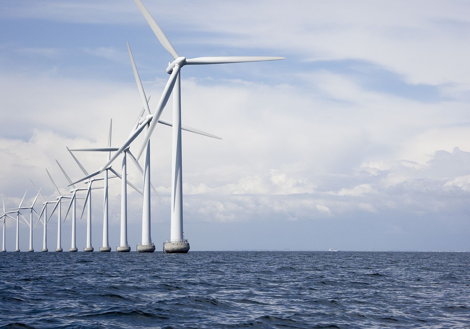 Image showing Long row of very tall offshore wind turbines