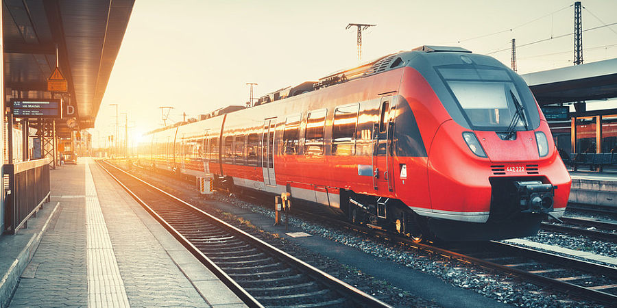 Image showing a modern train pulling into a station at sunrise