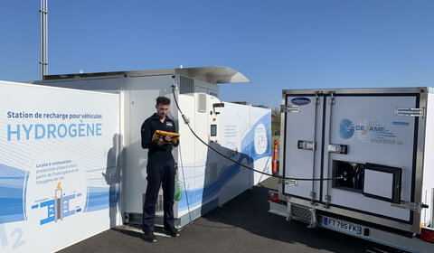 A technician monitors the Cesame-Exadebit mobile secondary measurement standard on a tablet computer while calibrating a hydrogen refuelling station