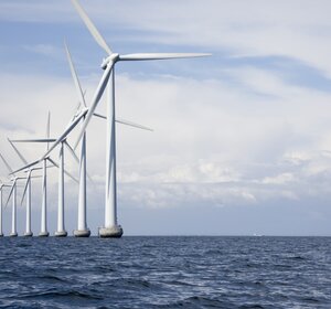 Image showing Long row of very tall offshore wind turbines