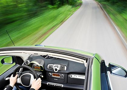 An electric car driving down a road Image showing an electric car driving down an empty road