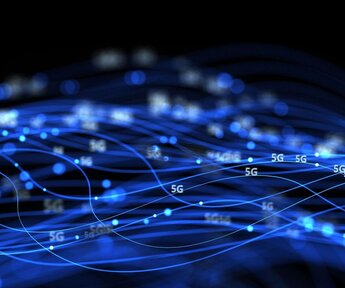 Against a dark background multiple bright blue stands of light interweave around the symbols “5G”