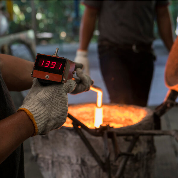 Image of worker measuring temperature at industrial site