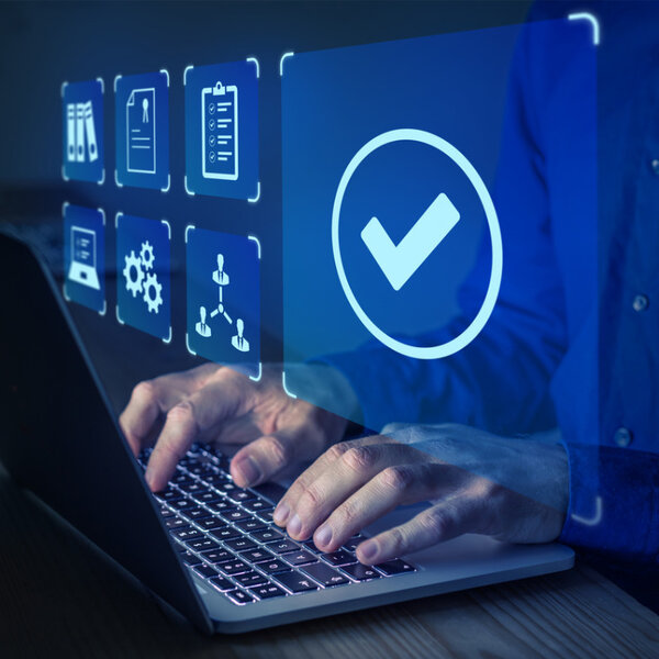 Close up of a man’s hands typing into the keyboard of a laptop. Superimposed is the screen he is working on showing various quality management icons