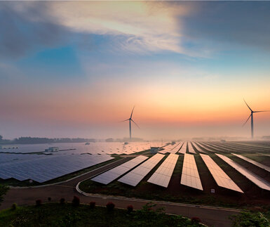 Image showing solar panels and wind turbines at sunrise
