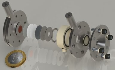 Computer-generated imagery of the vacuum-compatible operando battery cell in an explosion view was developed in OpMetBat. The specific design allows for the exchange of cell windows to address the different probes used in the project. The inner geometry represents the size of a CR2032 coin cell, which is mostly used in electrochemistry labs worldwide, and ensures a low barrier to interdisciplinary cooperation.