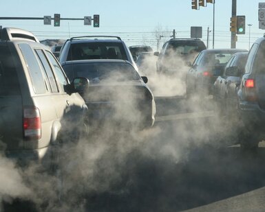 Image showing an intersection in Denver, Colorado, exhaust pours out of tailpipes from accelerating vehicles onto Santa Fe Drive