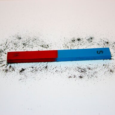 Image showing bar magnet. Iron filings show magnetic field lines.