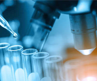 Microscope with lab glassware, science laboratory research and development concept