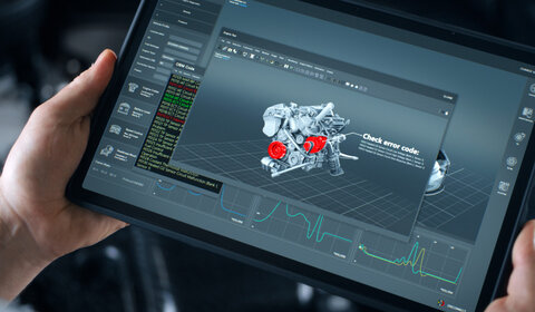 Close up of two hands holding a diagnostic pad showing a 3D schematic of a car engine. Two sections of the engine are in red indicating problematic areas