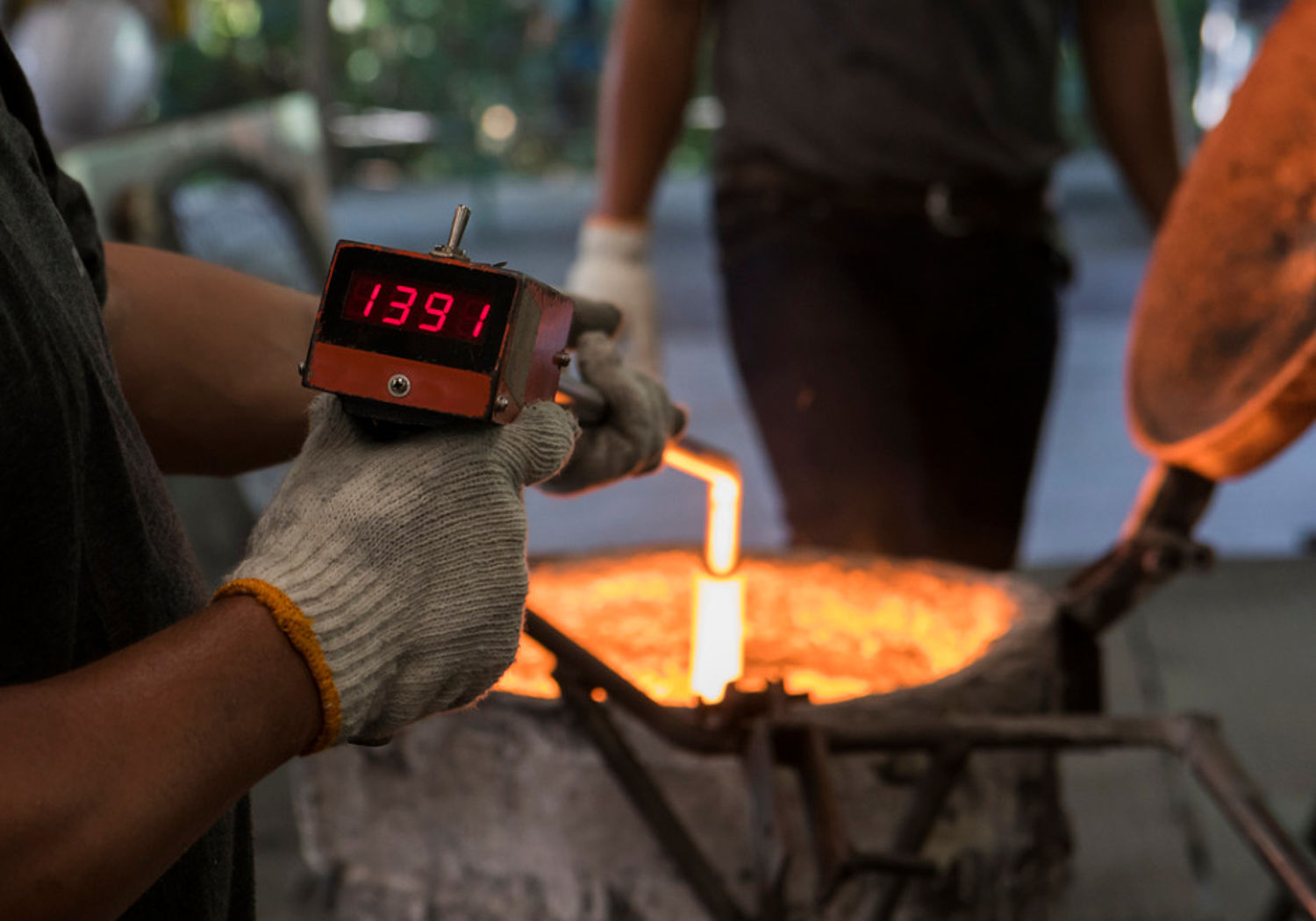 Image of worker measuring temperature at industrial site