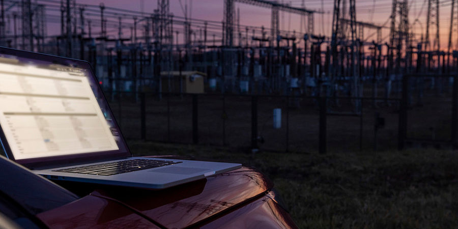 19NRM07 working on laptop near the electric power transmission equipment in picture id1369067638