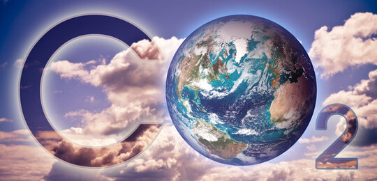 In the background are white clouds and a blue sky and set against these are the words “CO₂” with the “O” represented by the planet Earth