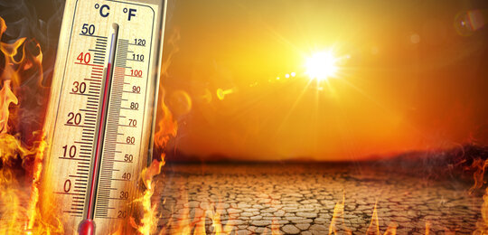 In an orange sky the sun beats down onto cracked dry earth with a burning thermometer on the left of the image reading over 40 degrees centigrade