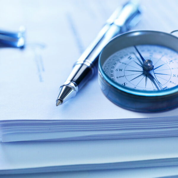 Image showing compass and pen on a stack of legal documents