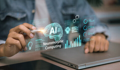 In the foreground of the image is a virtual screen with an image of a brain with “AI” in the centre and the words “Neuromorphic computing” underneath