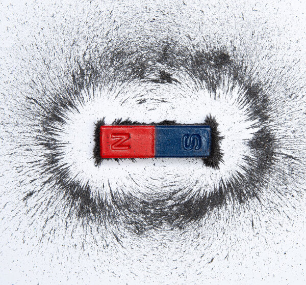 Image of a bar magnet with iron powder showing magnetic field