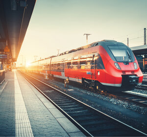Image showing a modern train pulling into a station at sunrise