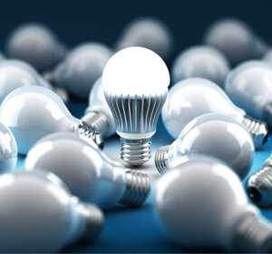 Image showing An LED bulb amongst old-style filament bulbs