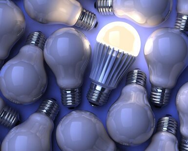 Image showing iIlluminated LED lamp among unlit incandescent lightbulbs