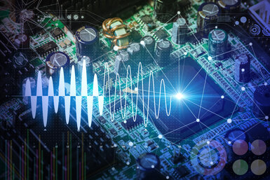 Close up of an electronic circuit board with transistors and connections overlayed with a graphic of a sine-wave representing the flow of digital information