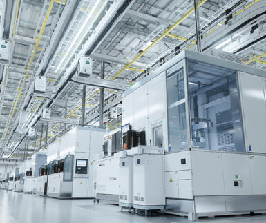 In a brightly lit and sterile semiconductor clean room rows of production booths spread out into the distance