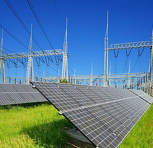 Solar energy panels in the background high voltage power substation
