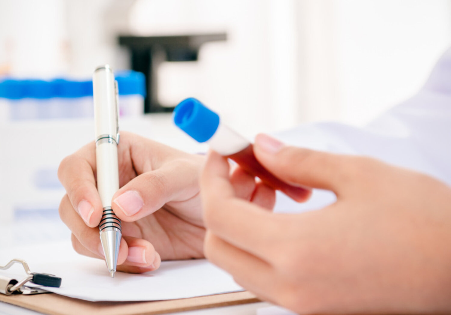Image of a scientist recording blood anaysis results in laboratory